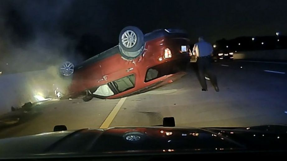 Still from a police dash cam shows a trooper walking around Janice Nicole Harper's overturned car on U.S. Highway 167 in Pulaski County, Ark., file photo, July 9, 2020.