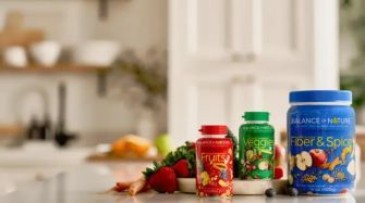 Bottles of Balance of Nature dietary supplements labeled "Fruits," "Veggies," and "Fiber & Spices" displayed on a kitchen counter.