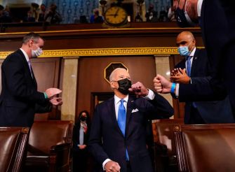 Biden greets lawmakers in the House chamber, emphasizing his administration's commitment to raising the immigration cap for refugees.
