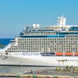 A cruise ship named Celebrity Reflection docked at a port with a clear blue sky and water in the background. A cruise ship named Celebrity Reflection docked at a port with a clear blue sky and water in the background.