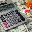 A calculator displaying "MEDICARE" on its screen, surrounded by U.S. currency and various prescription pills on a table. A calculator displaying "MEDICARE" on its screen, surrounded by U.S. currency and various prescription pills on a table.