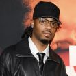 Metro Boomin at an event, wearing a black leather jacket and glasses. Metro Boomin at an event, wearing a black leather jacket and glasses.