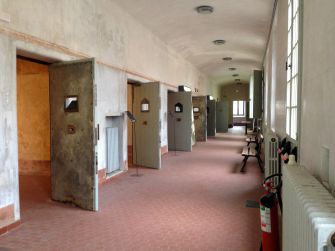 A hallway inside a youth correctional facility featuring multiple cell doors.