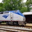 Amtrak train at a station surrounded by greenery. Amtrak train at a station surrounded by greenery.