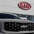 Kia logo displayed on dealership exterior with a Telluride vehicle in the foreground. Kia logo displayed on dealership exterior with a Telluride vehicle in the foreground.