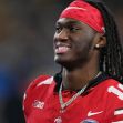 Marvin Harrison Jr. smiling while wearing a red football uniform and headband. Marvin Harrison Jr. smiling while wearing a red football uniform and headband.
