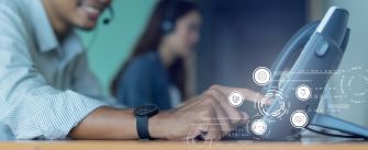 A person using a headset while operating a phone at a workplace, with digital communication icons overlayed.