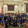 Group of students and advocates wearing blue shirts posing in a California legislative chamber. Group of students and advocates wearing blue shirts posing in a California legislative chamber.