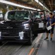 A Chevrolet vehicle on an assembly line with a worker inspecting it. A Chevrolet vehicle on an assembly line with a worker inspecting it.