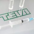 Syringe and vials on a surface featuring the Teva logo. Syringe and vials on a surface featuring the Teva logo.