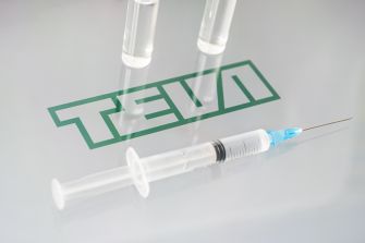 Syringe and vials on a surface featuring the Teva logo.