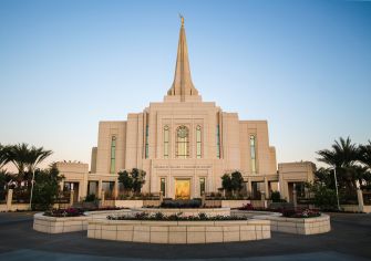 Exterior view of a temple belonging to The Church of Jesus Christ of Latter-Day Saints, featuring a tall steeple and surrounding landscaping.