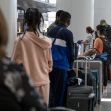 A queue of travelers at an airport security checkpoint, with individuals waiting to be processed. A queue of travelers at an airport security checkpoint, with individuals waiting to be processed.