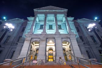 The exterior of the Colorado State Capitol building illuminated at night.
