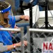 A person in a blue shirt processes ballots at a voting facility during an election audit. A person in a blue shirt processes ballots at a voting facility during an election audit.