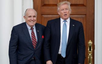 Rudy Giuliani and Donald Trump posing outside a building.