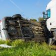 A truck and a flipped vehicle in a field, illustrating the aftermath of a trucking accident. A truck and a flipped vehicle in a field, illustrating the aftermath of a trucking accident.