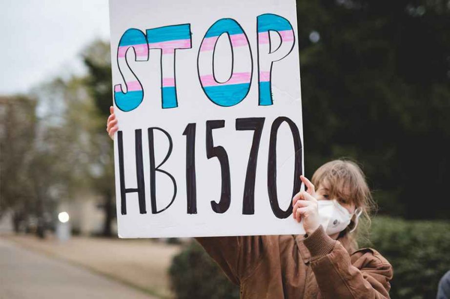 woman holding sign Stop Hb1570