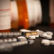 A close-up view of prescription pills and syringes, highlighting the opioid crisis and its impact on public health. A close-up view of prescription pills and syringes, highlighting the opioid crisis and its impact on public health.