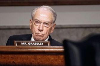 U.S. Senator Chuck Grassley sitting at a committee hearing with a serious expression.