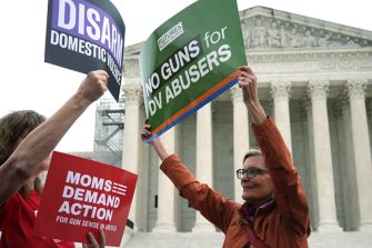 Demonstrators holding signs advocating for gun restrictions for domestic violence offenders outside the U.S. Supreme Court.
