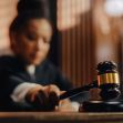 A blurred image of a judge holding a gavel in a courtroom setting. A blurred image of a judge holding a gavel in a courtroom setting.