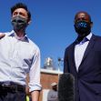 Two candidates for the Georgia runoff elections, Jon Ossoff and Raphael Warnock, speaking together outdoors while wearing masks. Two candidates for the Georgia runoff elections, Jon Ossoff and Raphael Warnock, speaking together outdoors while wearing masks.