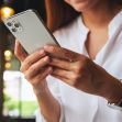 A person holding a smartphone, with a focus on their hands and the device. A person holding a smartphone, with a focus on their hands and the device.