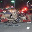 A severely damaged red car on a street after a deadly crash, with police officers and emergency vehicles in the background. A severely damaged red car on a street after a deadly crash, with police officers and emergency vehicles in the background.