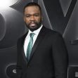 50 Cent posing in a formal outfit at a public event. 50 Cent posing in a formal outfit at a public event.
