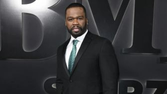 50 Cent posing in a formal outfit at a public event.