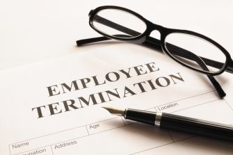 Document titled "Employee Termination" with glasses and a pen resting on it.