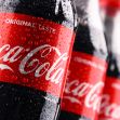 Bottles of Coca-Cola with condensation, showcasing the brand's iconic red label and logo. Bottles of Coca-Cola with condensation, showcasing the brand's iconic red label and logo.