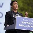 A woman speaking at a podium during a voting event, advocating for civic engagement and addressing community issues. A woman speaking at a podium during a voting event, advocating for civic engagement and addressing community issues.