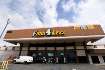 Exterior view of a Food 4 Less store, showing a clearance sale sign.