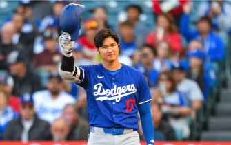 A baseball player in a blue Dodgers uniform waving to the crowd during a game.