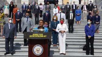 A group of lawmakers stands on the steps of a government building during a press conference advocating for the George Floyd Justice in Policing Act.