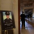 A placard with an image of the late U.S. Capitol Police officer Brian Sicknick on it as people wait for an urn with his cremated remains to be carried into the U.S. Capitol to lie in honor in the Capitol Rotunda in Washington, D.C., file photo, Feb. 2, 2021.