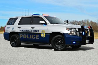 Prince George's County police vehicle parked on a gravel surface with emergency lights activated.
