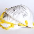A stack of N95 respirator masks with yellow straps. A stack of N95 respirator masks with yellow straps.