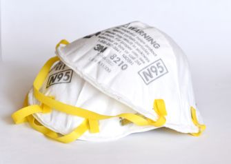 A stack of N95 respirator masks with yellow straps.