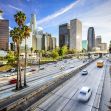 A bustling highway scene in Los Angeles with skyscrapers in the background and vehicles driving under a clear blue sky. A bustling highway scene in Los Angeles with skyscrapers in the background and vehicles driving under a clear blue sky.