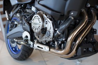 Close-up of a Yamaha motorcycle engine and exhaust system.