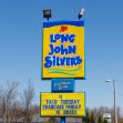 Sign for Long John Silver’s restaurant displaying promotions and branding. Sign for Long John Silver’s restaurant displaying promotions and branding.