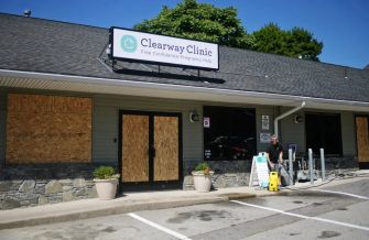 Exterior view of the Clearway Clinic, a crisis pregnancy center in Worcester, Massachusetts, with boarded windows and signage indicating it offers free confidential pregnancy help.