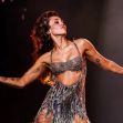 Miley Cyrus performing on stage in a shimmering outfit. Miley Cyrus performing on stage in a shimmering outfit.