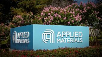 Sign for Applied Materials surrounded by flowers and greenery.