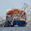 A cargo ship with a toppled section of the Francis Scott Key Bridge in the background, illustrating the aftermath of a maritime accident. A cargo ship with a toppled section of the Francis Scott Key Bridge in the background, illustrating the aftermath of a maritime accident.