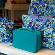 Display of Vera Bradley bags and accessories with a floral pattern and a teal-colored handbag. Display of Vera Bradley bags and accessories with a floral pattern and a teal-colored handbag.
