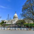 U.S. Capitol building surrounded by security fencing on a clear day. U.S. Capitol building surrounded by security fencing on a clear day.
